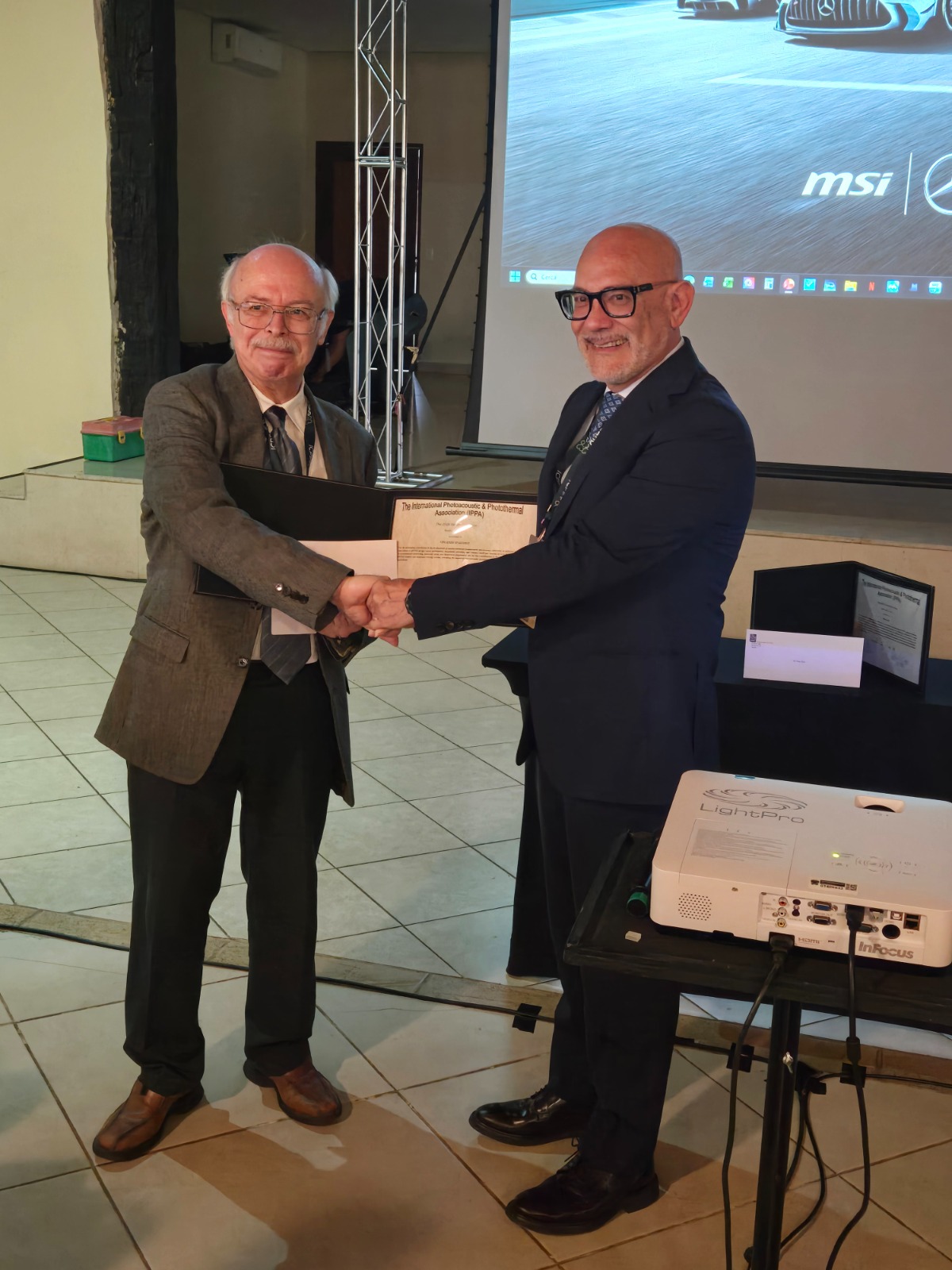 il prof. Vincenzo Spagnolo riceve il riconoscimento dal prof. Andreas Mandelis, Presidente IPPA